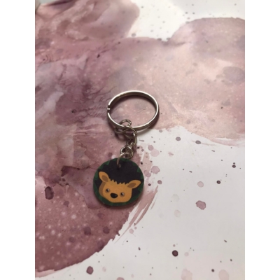 Ezüstszínű kulcskarikáról láncon lóg le egy barna színű sündisznó.