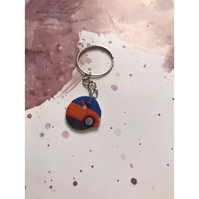 Ezüstszínű kulcskarikáról láncon lóg le egy kocsi.