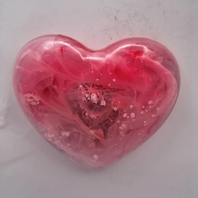 Szív alakú mágnes, amelyen erőteljes pink szín dominál, finom fehér foltokkal. A színek intenzíven keverednek, virágzó hatást keltve.